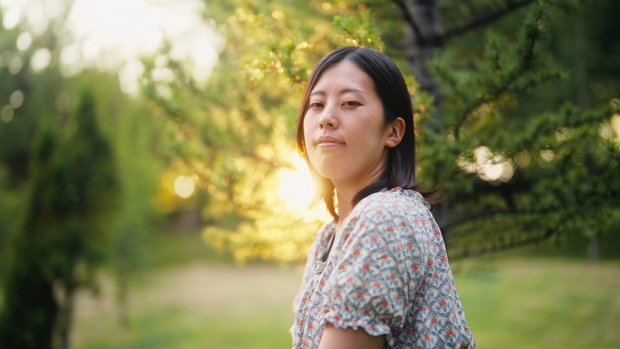 日落时自然中的年轻女子的肖像视频素材