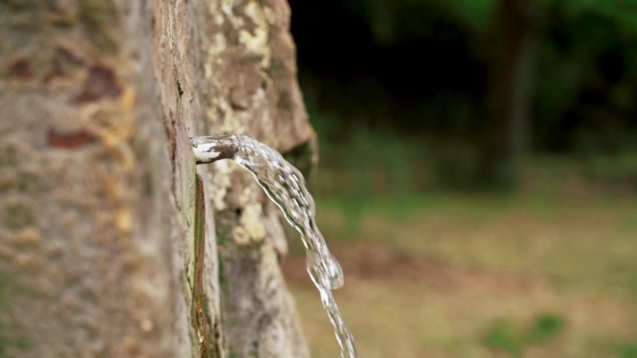 泉水纯净，矿泉纯天然，水在一堵石壁上，在一处夏日山林中视频素材