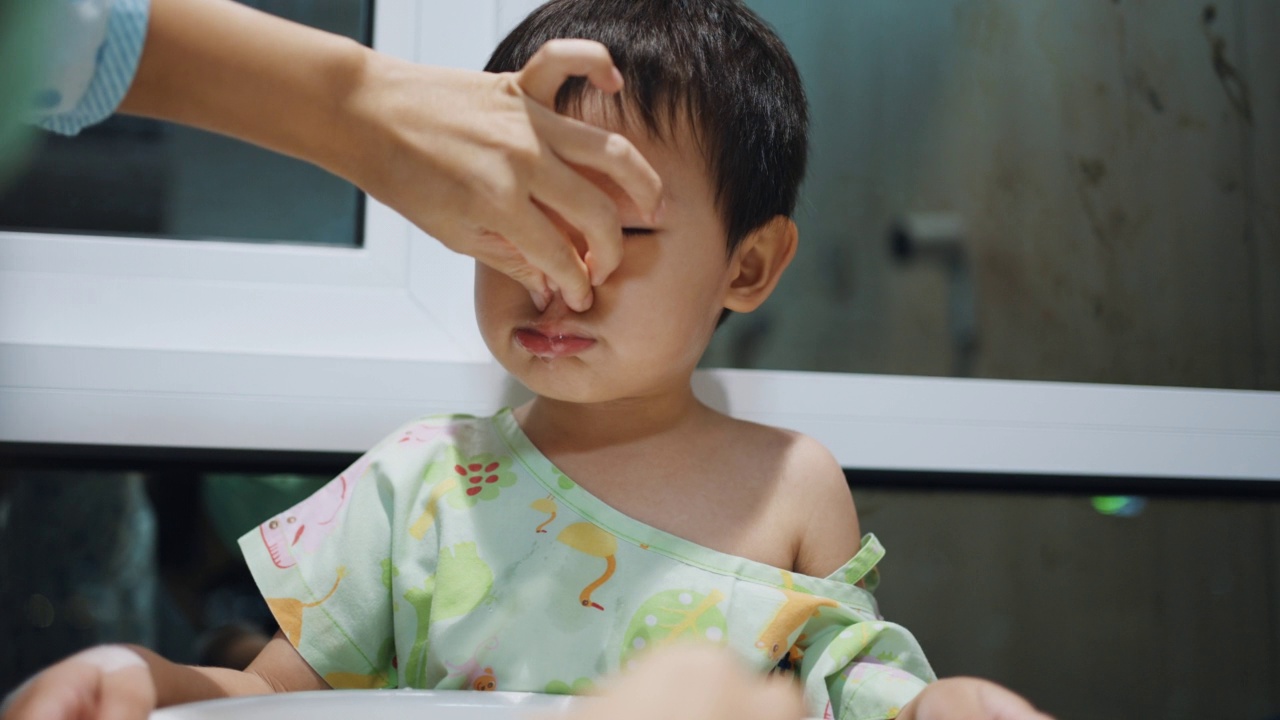 妈妈在帮她的小男孩用生理盐水清洗鼻腔视频素材