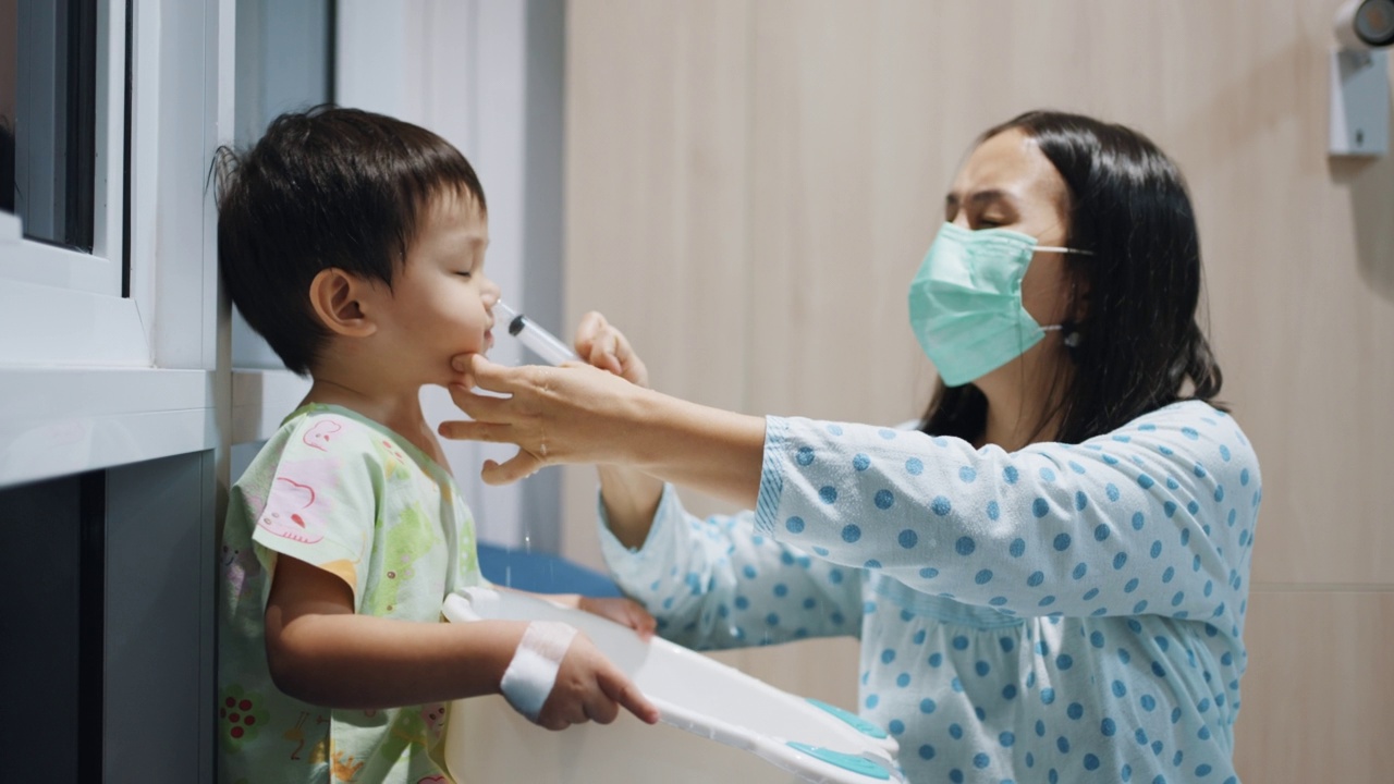 妈妈在帮她的小男孩用生理盐水清洗鼻腔视频素材