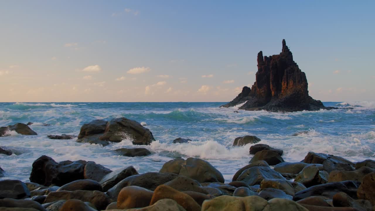 在加那利群岛特内里费岛的贝尼霍海滩，在美丽的夕阳和阳光下，令人惊叹的宏伟波浪上升在空中。海洋中独特的巨浪撞击着岩石，溅起水花。视频素材