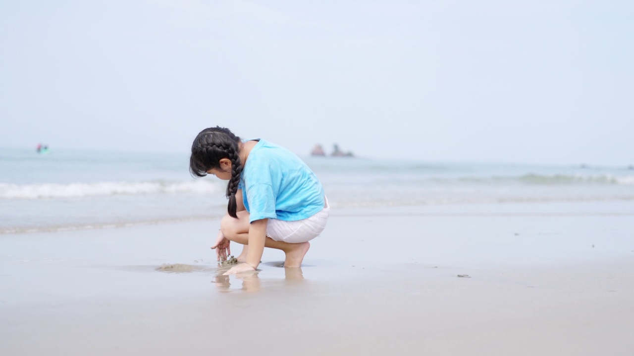 4K小亚洲女孩在夏日阳光明媚的热带海滩上散步和玩耍。视频素材