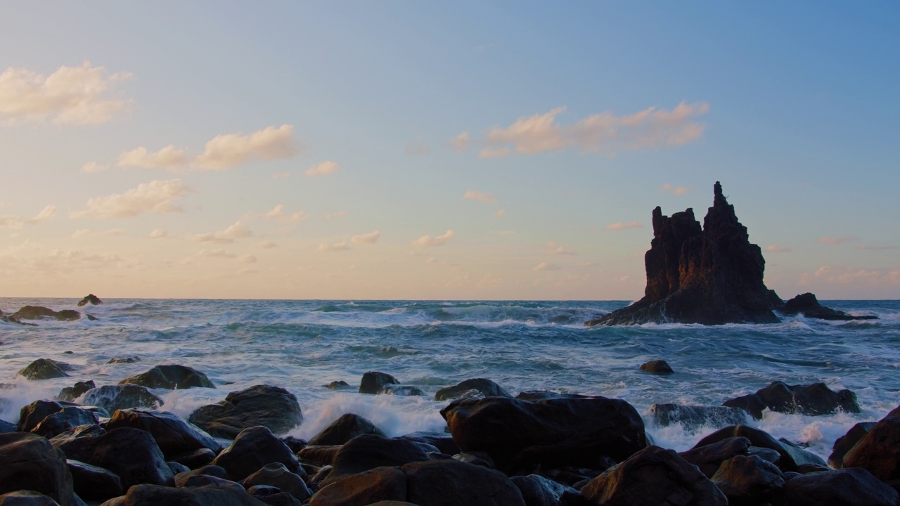 在加那利群岛特内里费岛的贝尼霍海滩，在美丽的夕阳和阳光下，令人惊叹的宏伟波浪上升在空中。海洋中独特的巨浪撞击着岩石，溅起水花。视频素材