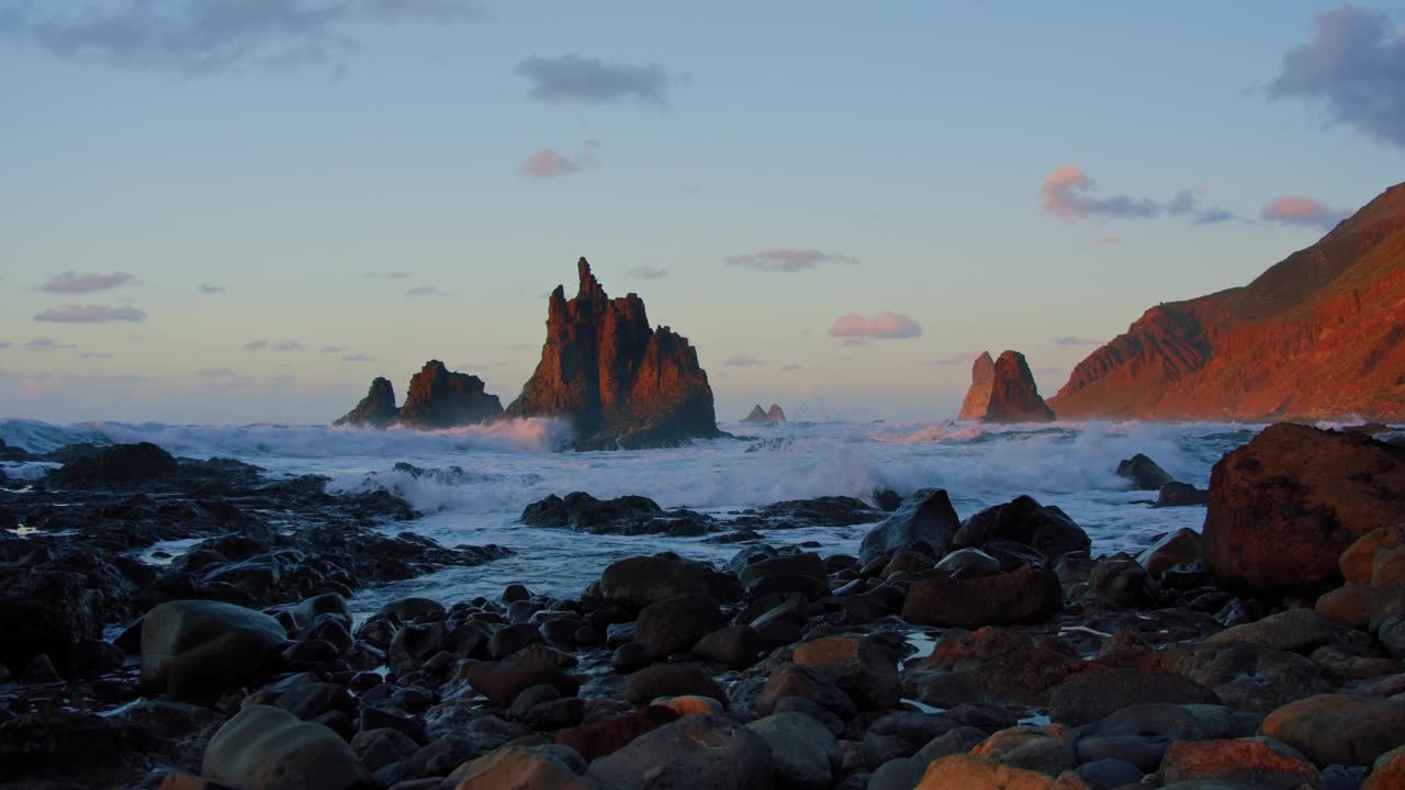 在加那利群岛特内里费岛的贝尼霍海滩，在美丽的夕阳和阳光下，令人惊叹的宏伟波浪上升在空中。海洋中独特的巨浪撞击着岩石，溅起水花。视频素材