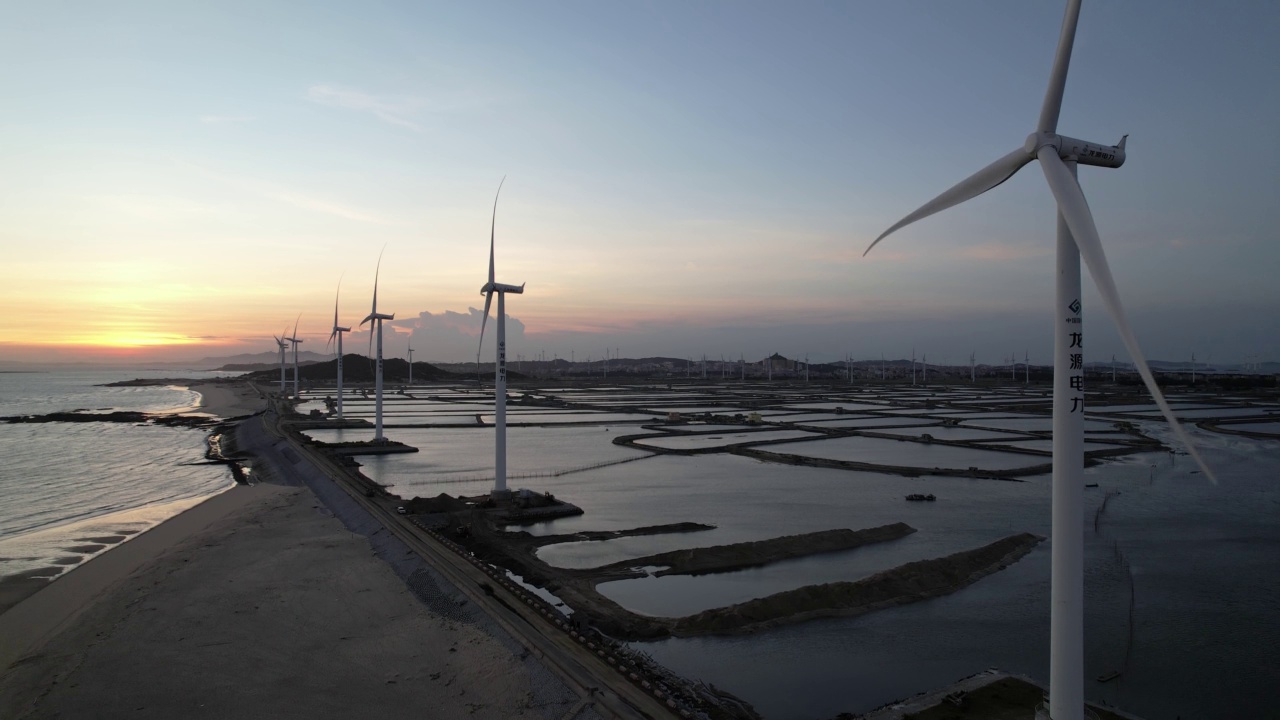 黄昏时分海滩上风电场的鸟瞰图视频素材