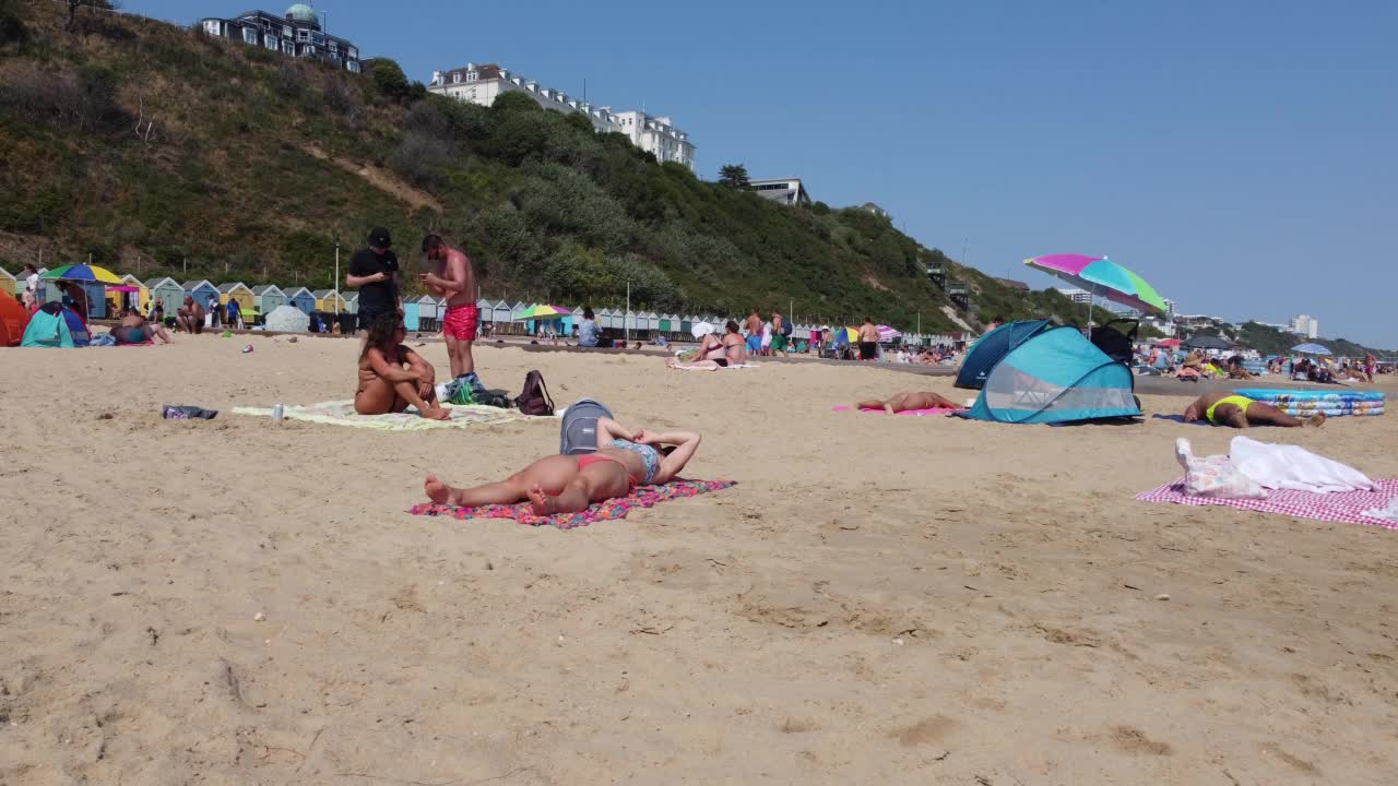 高角度海景海滩前与人在英国伯恩茅斯市，英国海洋的航拍镜头视频素材