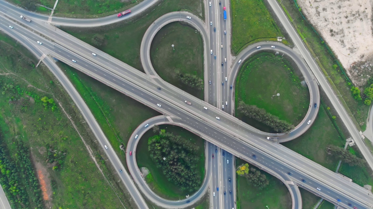 鸟瞰图交通枢纽道路与U弯车道城市交通工业。无人机飞过城市路口的道路。全景垂直空中洲际。视频素材