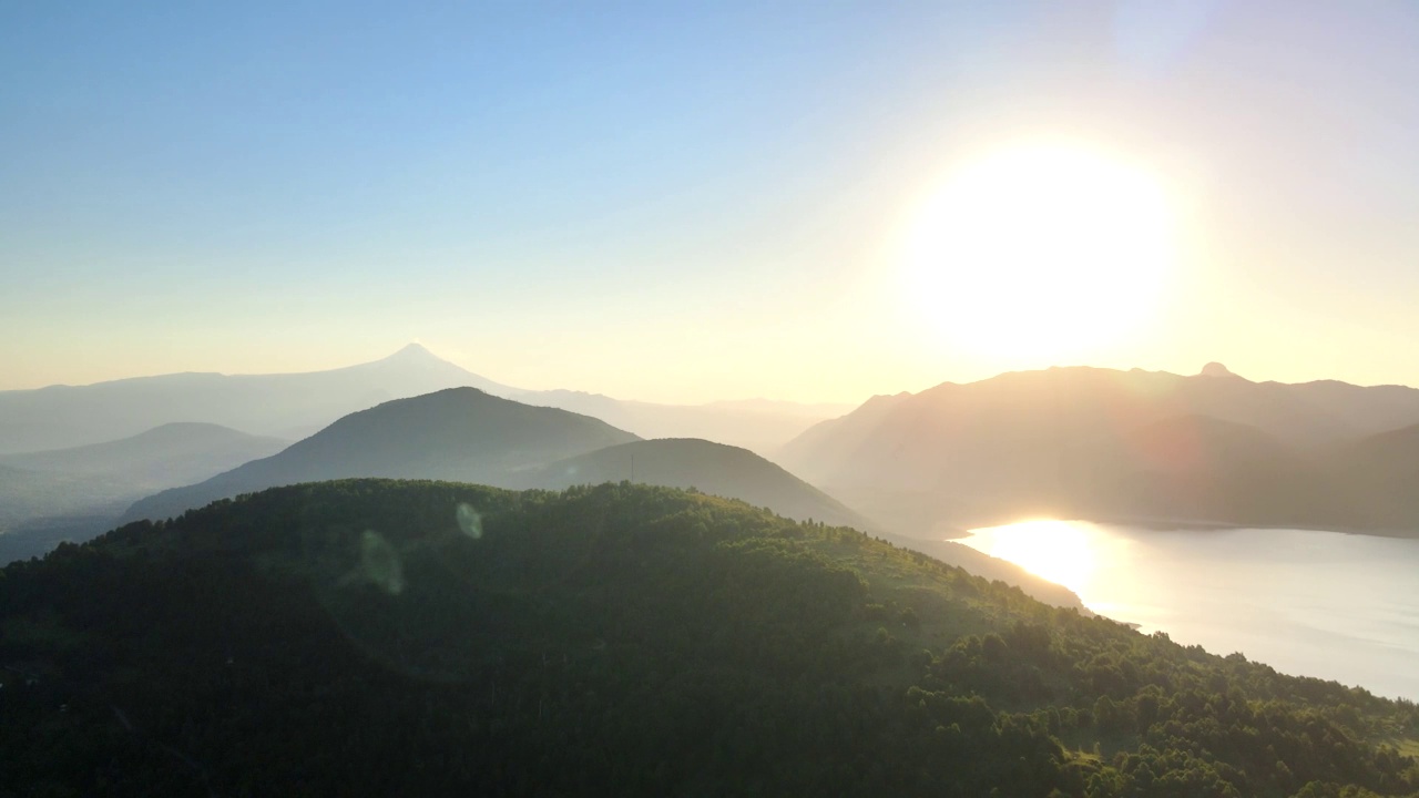 日光下的山脉全景图，智利南部的维拉里卡火山和卡布瓜湖的鸟瞰图视频素材