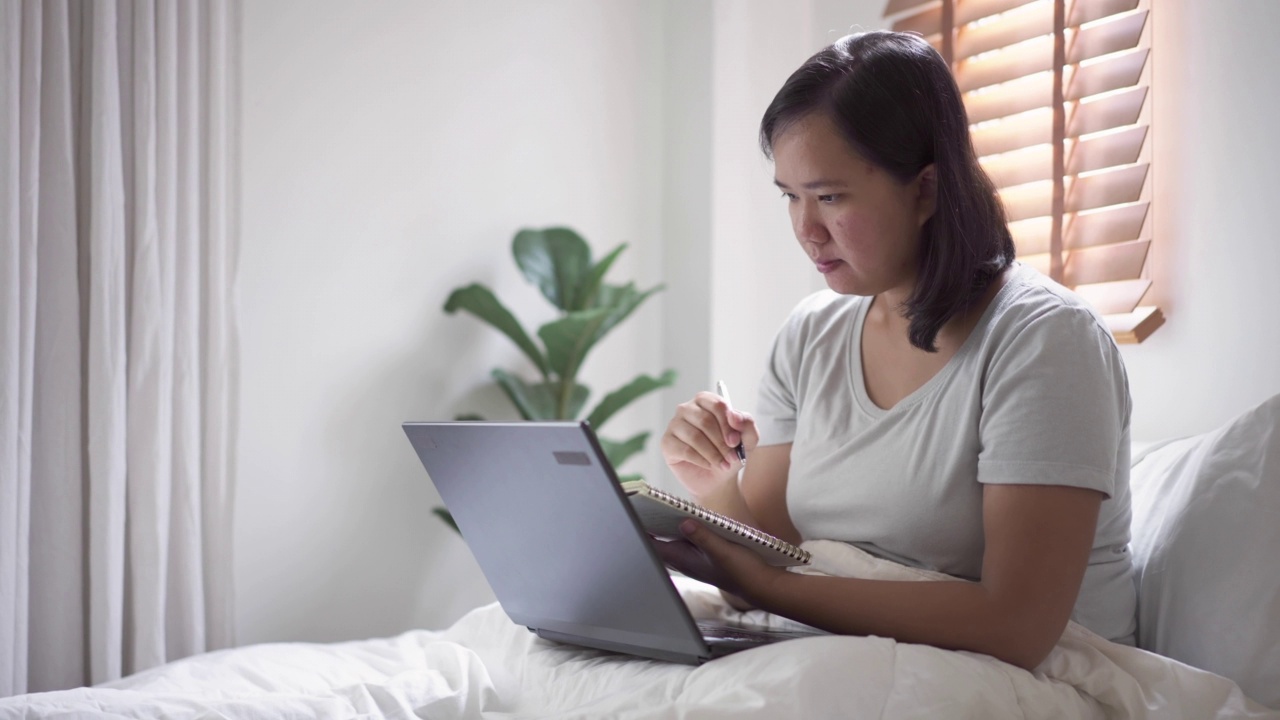 女性在家通过笔记本电脑在线教育自学视频素材