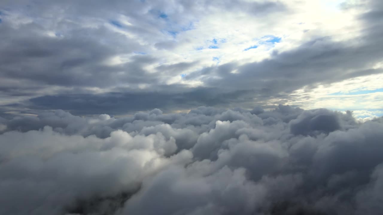 在暴雨来临前，地面覆盖着蓬松的积云，从飞机窗口俯瞰视频素材