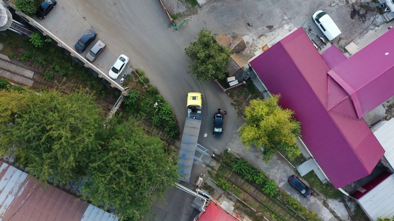谷物车或自卸车正驶过谷物提升仓的工业区。空体拖车沿道路行驶的俯视图。无人机直升机镜头。视频素材画面1