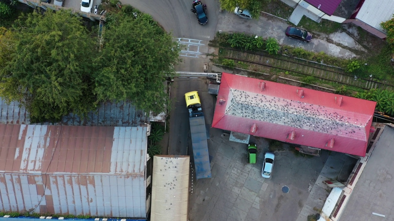 谷物车或自卸车正驶过谷物提升仓的工业区。空体拖车沿道路行驶的俯视图。无人机直升机镜头。视频素材画面2