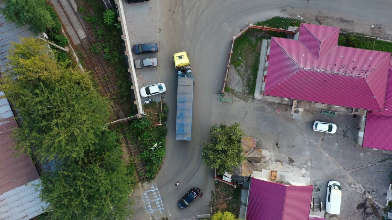 谷物车或自卸车正驶过谷物提升仓的工业区。空体拖车沿道路行驶的俯视图。无人机直升机镜头。视频素材画面3
