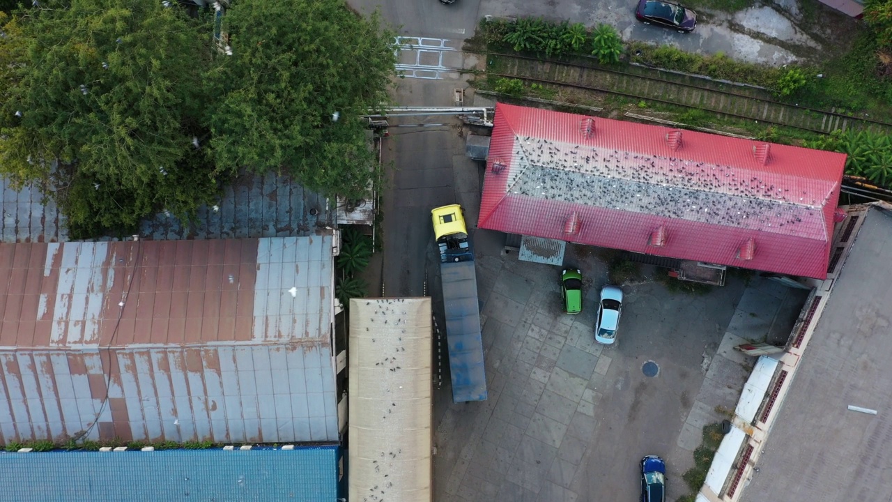 谷物车或自卸车正驶过谷物提升仓的工业区。空体拖车沿道路行驶的俯视图。无人机直升机镜头。视频素材画面4