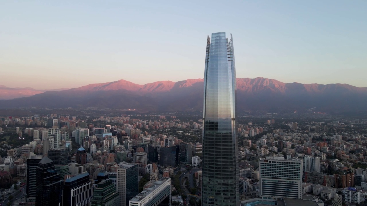 高空视差的幕墙科斯坦纳拉中心摩天大楼，背景雷蒙山，在现代圣哈坦地区在蓝色时间，智利圣地亚哥视频素材