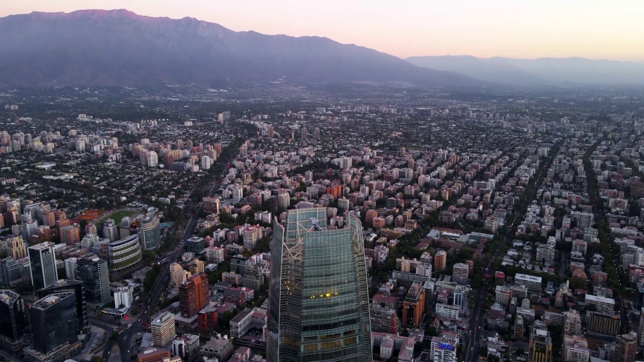 从科斯坦纳拉中心摩天大楼和拉蒙山的背景在现代圣哈坦地区在蓝色的小时，智利首都圣地亚哥视频素材