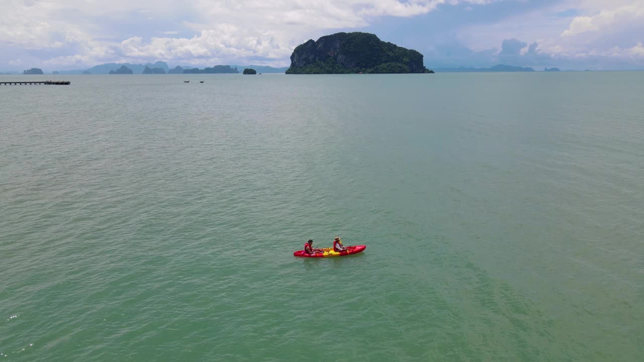 男人和女人在泰国普吉岛附近的海洋里划皮艇视频素材