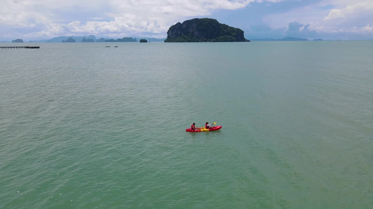 男人和女人在泰国普吉岛附近的海洋里划皮艇视频素材