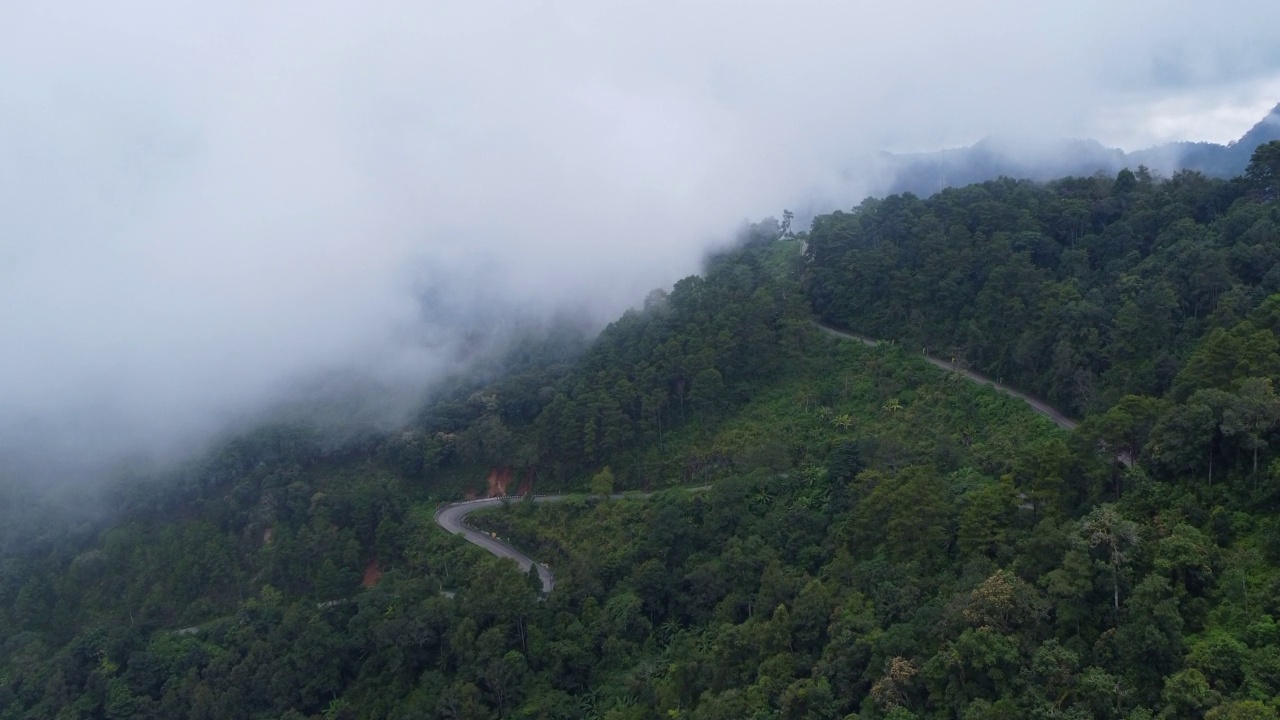 泰国山顶公路的鸟瞰图，上面有美丽的绿色森林。动态的自然景观背景。旅游和交通概念视频素材