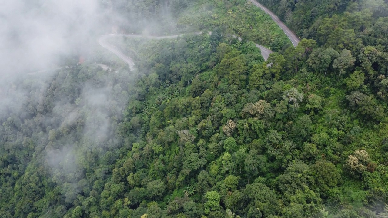 泰国山顶公路的鸟瞰图，上面有美丽的绿色森林。动态的自然景观背景。旅游和交通概念视频素材