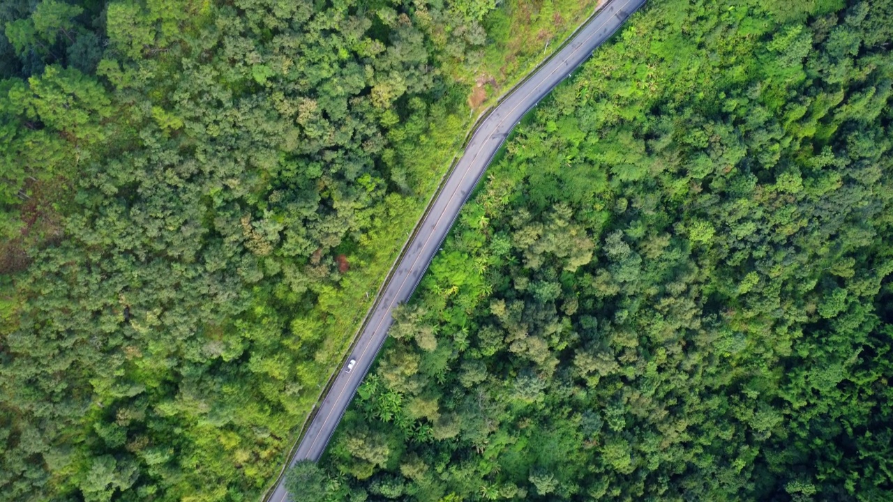 泰国山顶公路的鸟瞰图，上面有美丽的绿色森林。动态的自然景观背景。旅游和交通概念视频素材