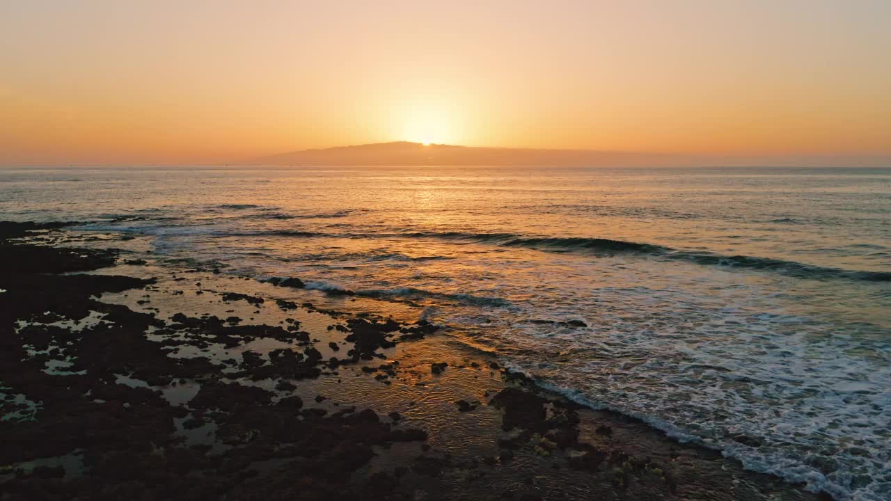 美丽的日落在天堂梦幻岛屿。太阳路径上海水表面咸咸的，海水金黄清澈。晚上的风景。海浪泡沫。无人机飞向太阳。视频素材