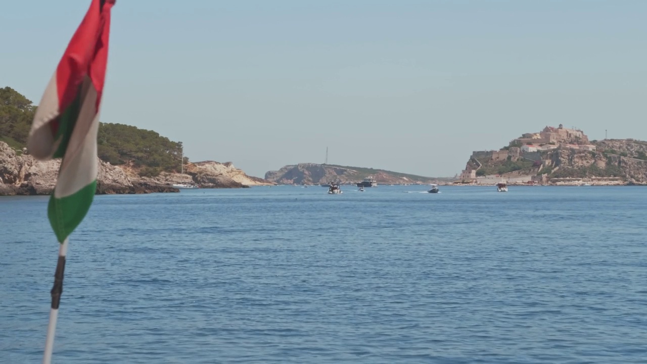 从船上看特里米提群岛的海岸线和清澈的大海。前景是意大利国旗固定在船上。阿普利亚,意大利视频素材