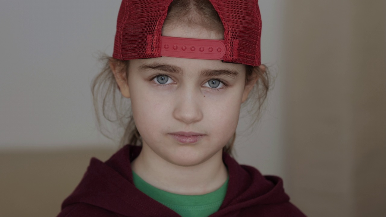 戴着红色棒球帽、金发的年轻严肃女孩在室内看着摄像机。肖像可爱严肃的孩子严肃沉思
担心白人少年。悲伤自信的小女孩。人类的脸。视频素材