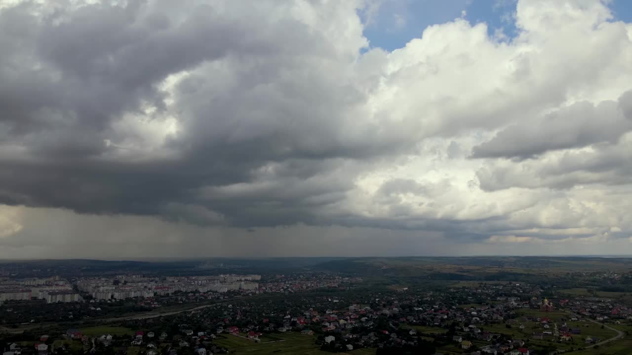 从高空鸟瞰图，远处的城市被暴雨前形成的蓬松积云覆盖视频素材