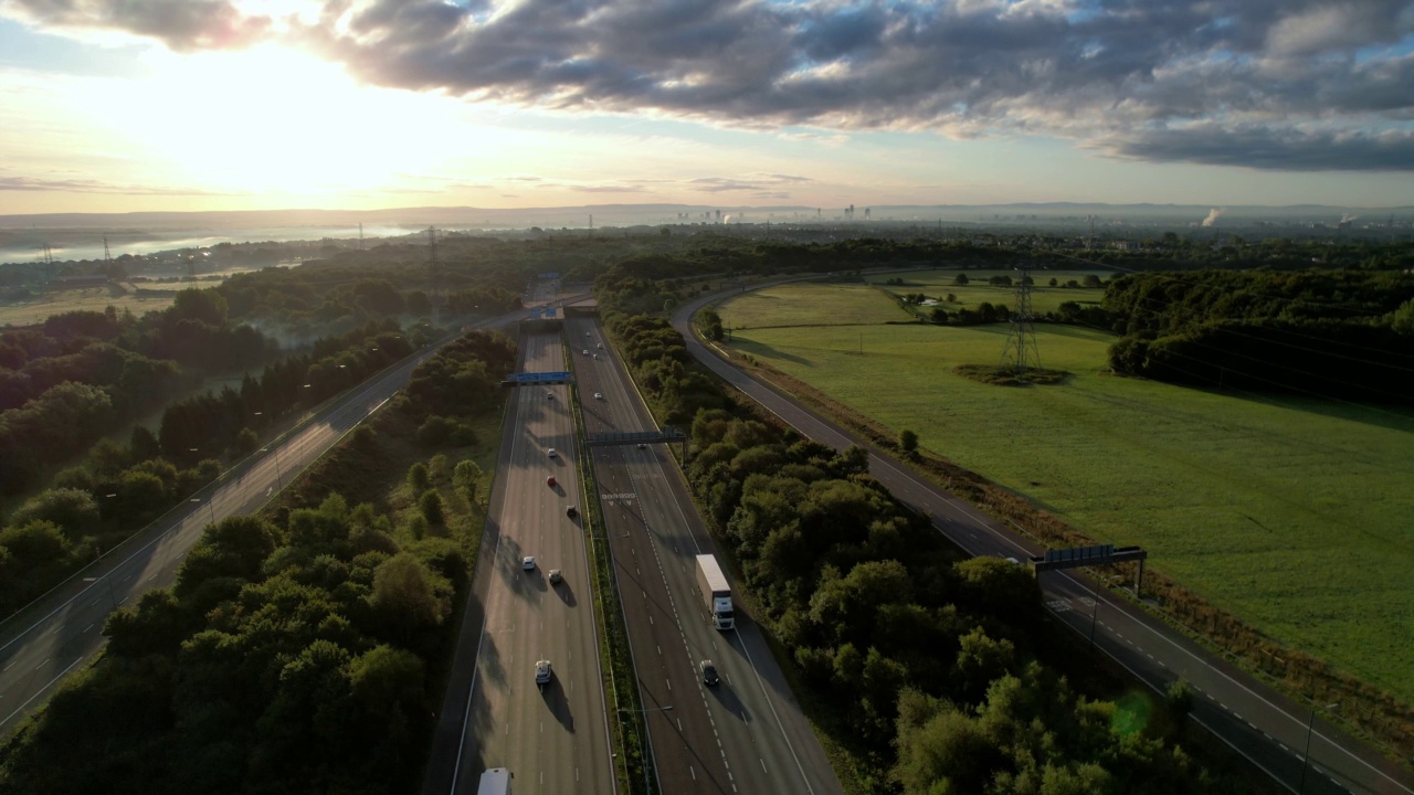 4K无人机鸟瞰高速公路高速公路多路口道路与移动的汽车在日出。汽车在路上行驶。视频下载