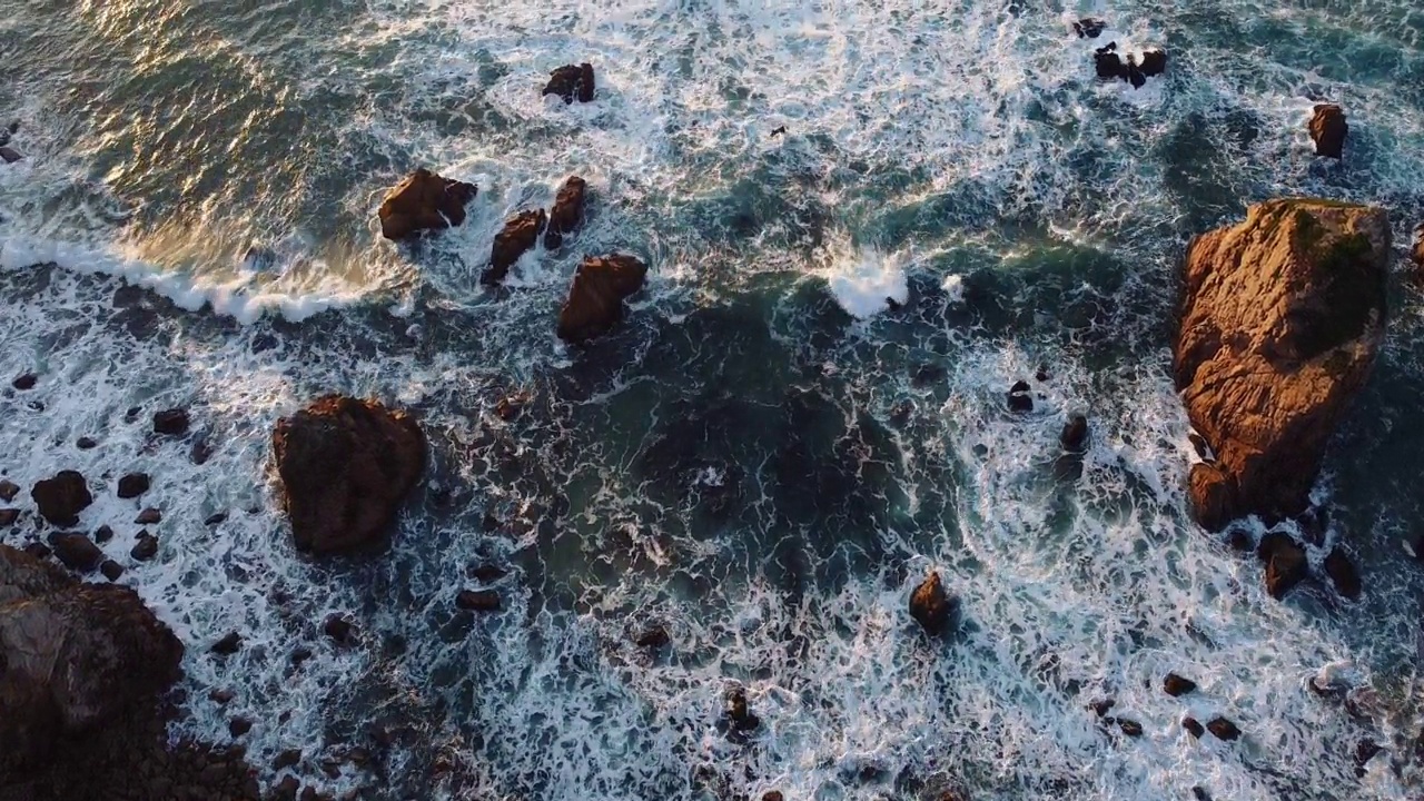 航拍的海浪撞击葡萄牙阿尔加维海滩岸边的岩石视频素材