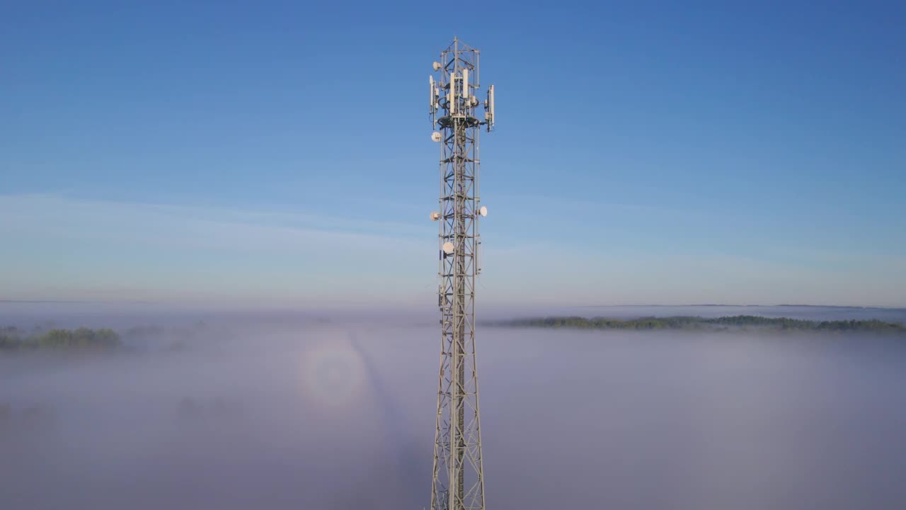 塔式天线电信手机鸟瞰图，蜂窝5g 4g手机无线电发射机。提供高速现代5g交通网络服务。日出时分的雾、云和天空视频素材