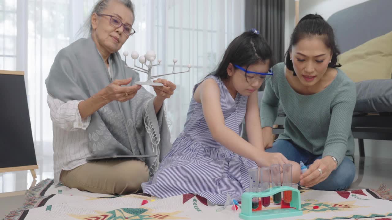 奶奶和妈妈在客厅教可爱的女儿，女孩，孙女，奶奶，学习概念。视频素材