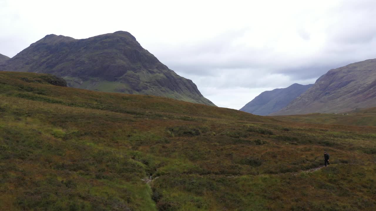 航拍的徒步旅行者在美丽的戏剧性的Buachaille Etive Mor，在一个灰色的阴天在苏格兰高地-苏格兰著名的山视频素材