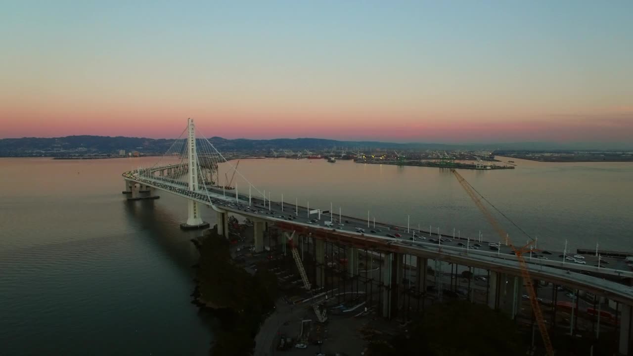 空中拍摄的汽车和车辆在桥梁道路上移动，无人机在日落飞越海洋-旧金山，加利福尼亚州视频素材