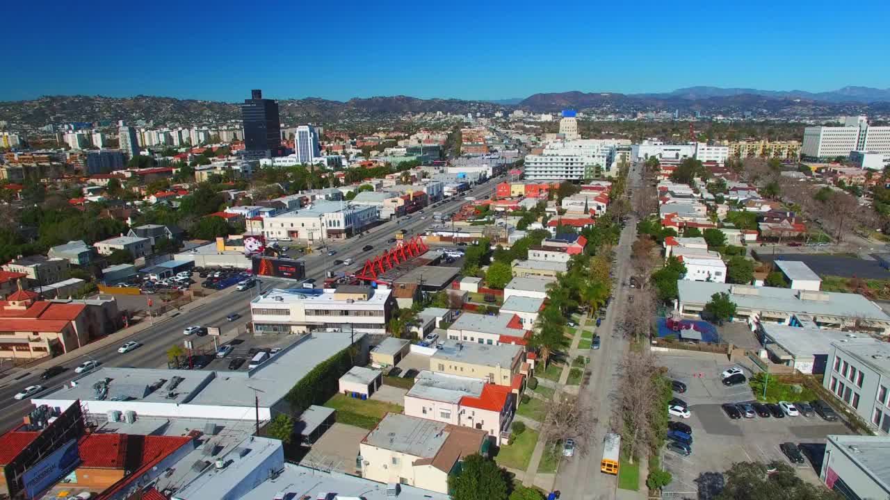 航拍:无人机在阳光明媚的日子里飞行，在山边城市的住宅建筑的航拍镜头——加利福尼亚州的洛杉矶视频素材