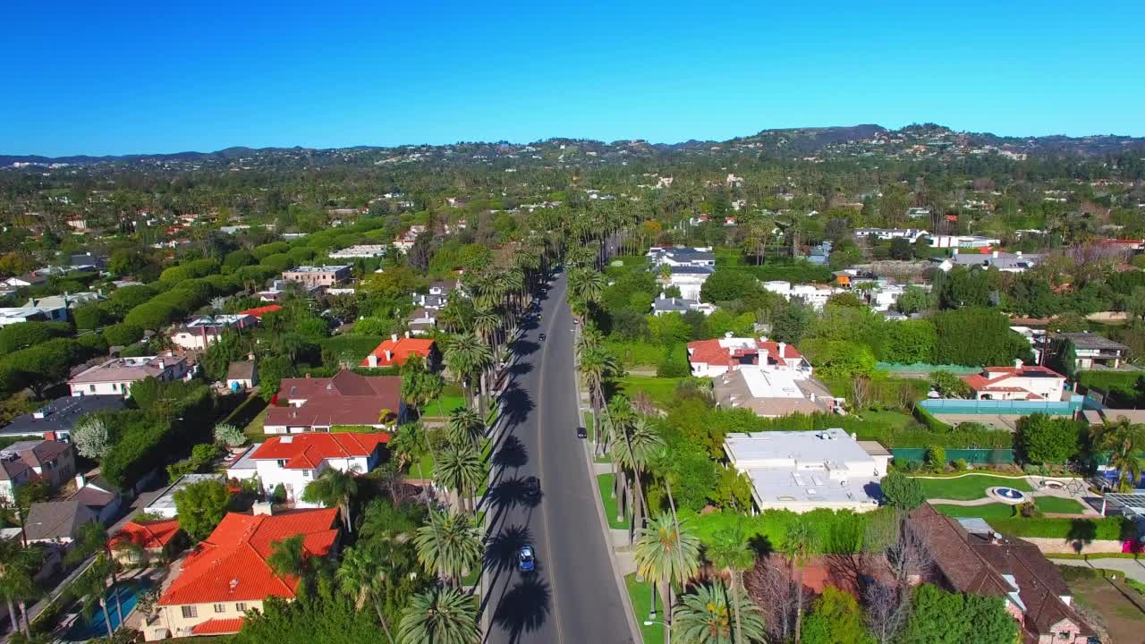 航拍的道路中住宅在城市，无人机在阳光灿烂的日子向后飞行-比弗利山，加利福尼亚州视频素材