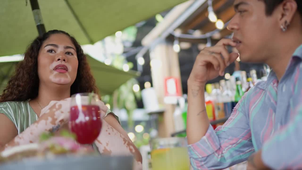 年轻女子在酒吧里和朋友聊天视频素材