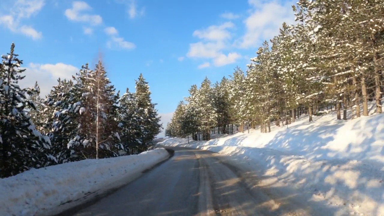 汽车在冬天的驾驶板，仪表盘摄像头pov镜头的道路在雪景在Zlatibor山视频素材