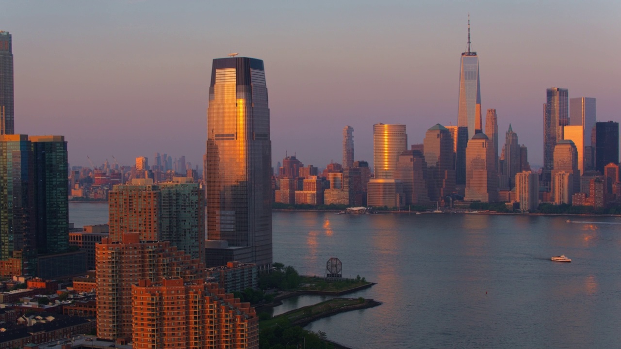 日落时分，从泽西城的保卢斯胡克(Paulus Hook)俯瞰哈德逊河(Hudson River)上的曼哈顿市中心。航拍镜头向前平移运动。视频素材