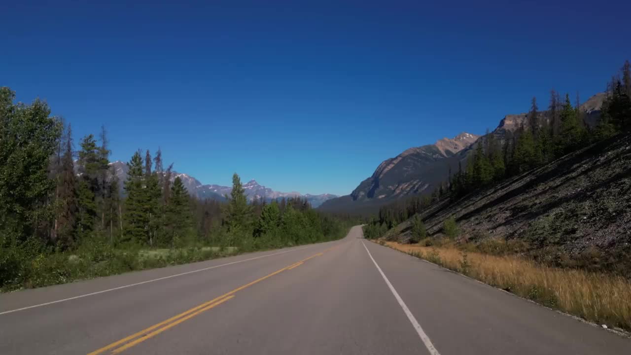 在加拿大落基山脉为背景的道路上开车的4K镜头视频素材