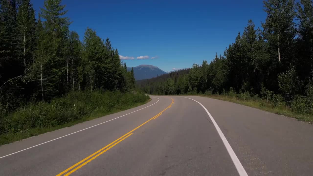 在加拿大落基山脉为背景的道路上开车的4K镜头视频素材