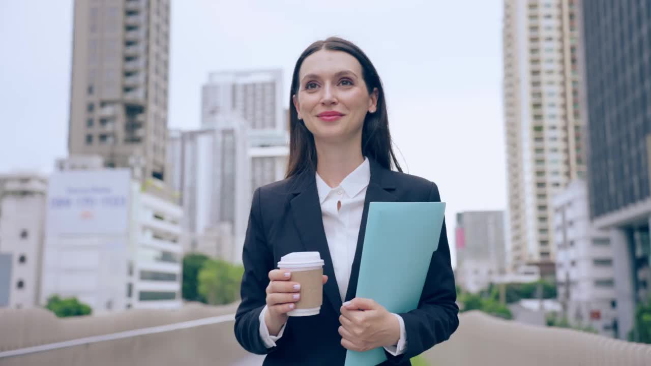 白种女商人拿着咖啡走在城市的户外。迷人美丽的女职员工人人们感到快乐和自信的同时花时间走到办公室的公司。视频素材