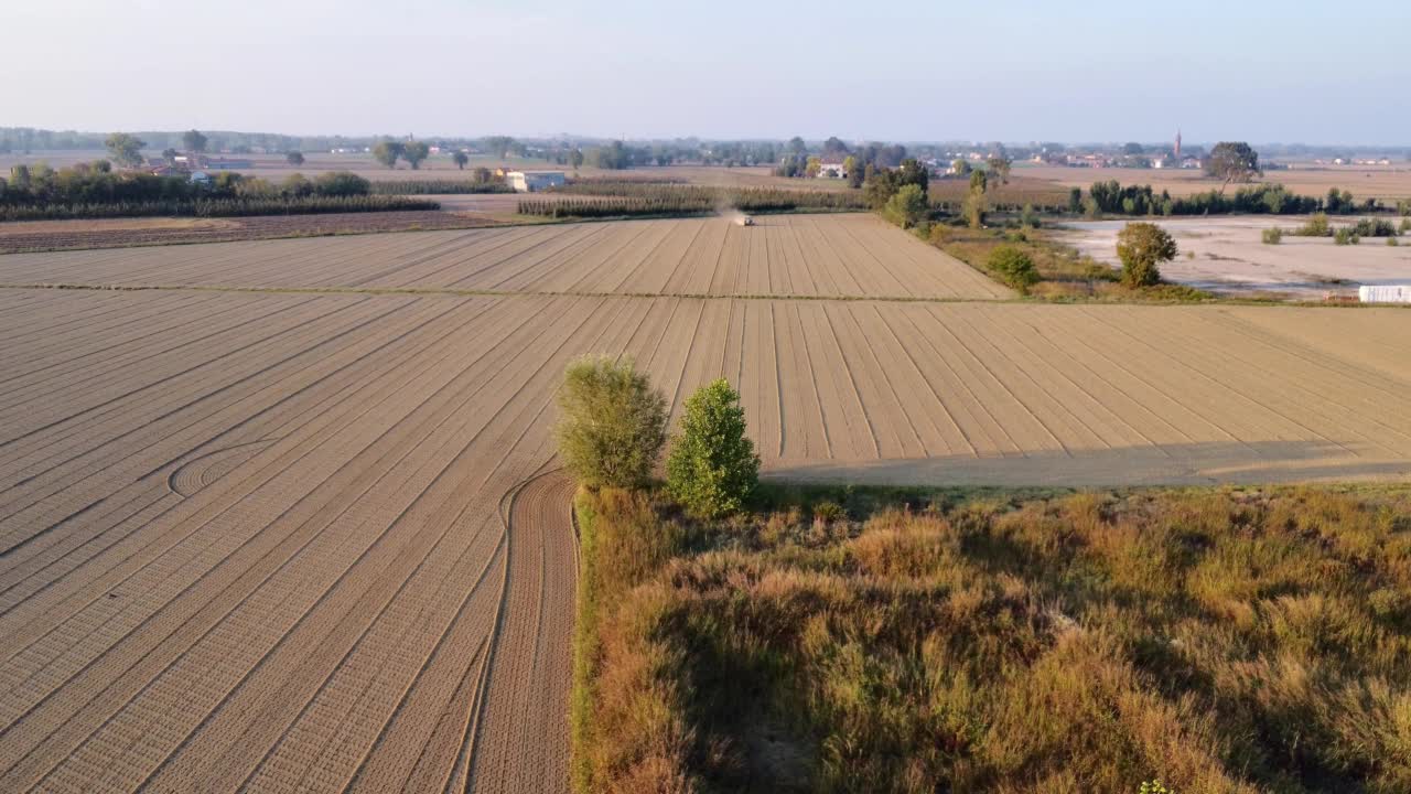 拖拉机用滚轮骑着田地挤压地面，夯实平整土壤表面视频素材