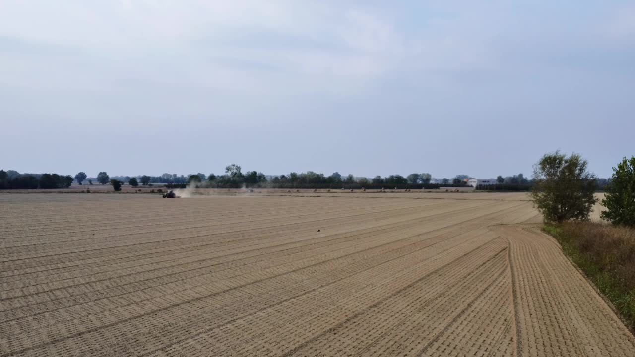 拖拉机用滚轮骑着田地挤压地面，夯实平整土壤表面视频素材