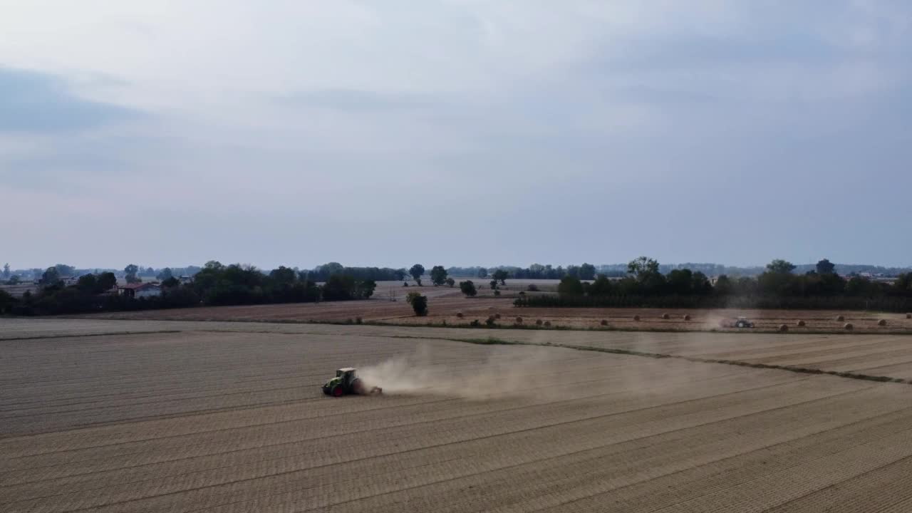 拖拉机用滚轮骑着田地挤压地面，夯实平整土壤表面视频素材