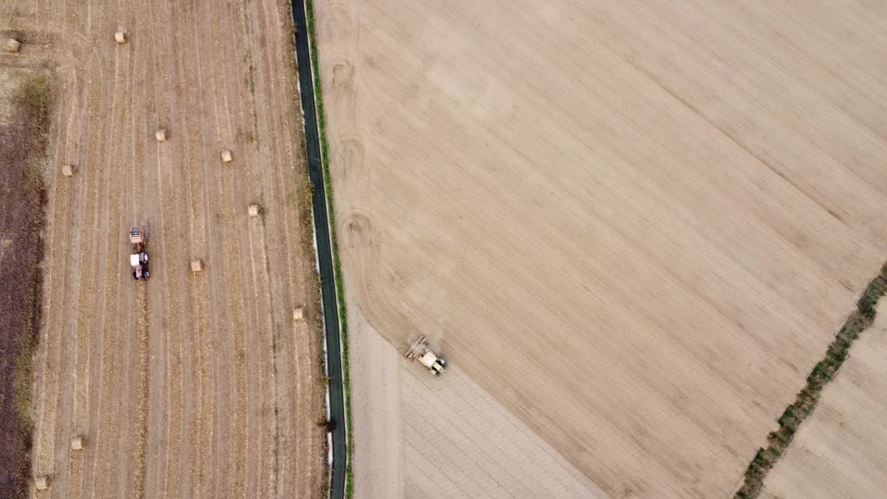 拖拉机用滚轮骑着田地挤压地面，夯实平整土壤表面视频素材