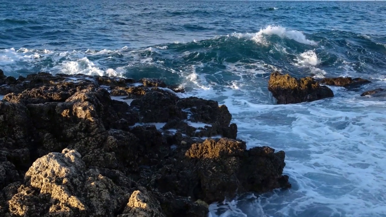 海浪，岩石，慢动作。巨浪拍打着石滩。视频素材