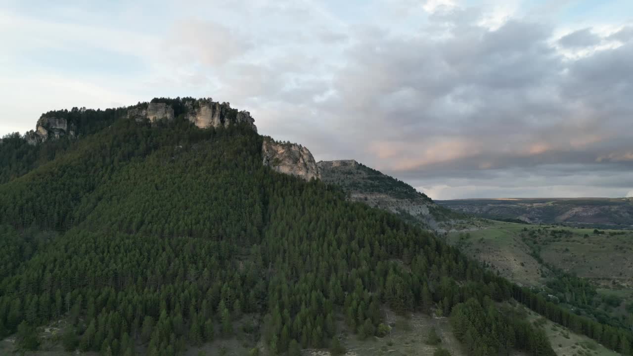 航拍的山区景观与树木在黄昏在多云的天空背景视频素材