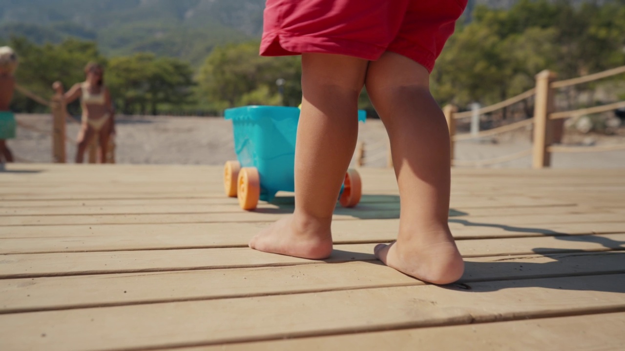 孩子们的光脚。平脚。孩子光着脚走在木桥上。视频素材画面2